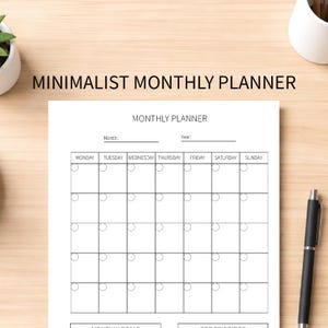 May include: A minimalist monthly planner with a white background. The planner includes a calendar grid with spaces for each day of the week, and lines for the month and year. A black pen rests on the right side of the planner.