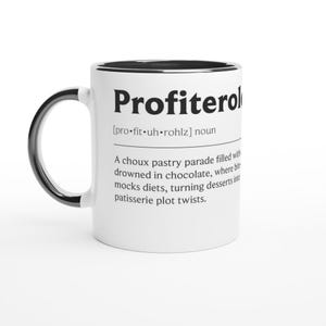 Pode incluir: Caneca de cerâmica branca com alça e borda pretas. A caneca apresenta a palavra "Profiterol" em letras pretas em negrito, juntamente com uma definição. A definição descreve uma massa choux recheada com chocolate.