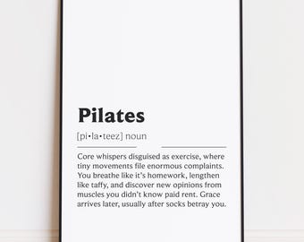 May include: A framed print with the definition of "Pilates" in black text on a white background. The definition includes the pronunciation and a humorous description of the exercise. The frame is black.
