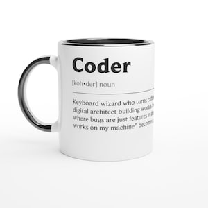 Può includere: Tazza in ceramica bianca con manico e bordo neri. La tazza presenta la parola "Coder" in grassetto nero, insieme a una definizione. La definizione descrive un coder come un "mago della tastiera" e un "architetto digitale".