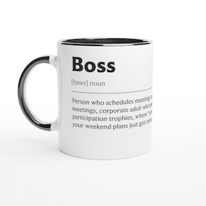 May include: White ceramic mug with a black handle and rim. The mug features the word "Boss" in bold black letters, along with a definition. The definition includes the phrase "Person who schedules meetings".