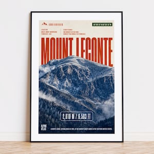 May include: A framed poster featuring Mount LeConte in the Great Smoky Mountains, Tennessee. The poster includes the mountain's elevation, 2,010 m, and other details in a vintage style. The text "Mount LeConte" is prominently displayed in large, red letters.
