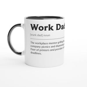 Può includere: Tazza in ceramica bianca con interno e manico neri. La tazza presenta il testo "Work Dad" in grassetto nero, insieme a una definizione. La definizione descrive un mentore sul posto di lavoro, un riparatore di stampanti e un fornitore di scadenze.
