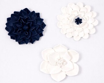 Arte mural con flores azul marino y blancas: esculturas de anémona, dalia y magnolia.