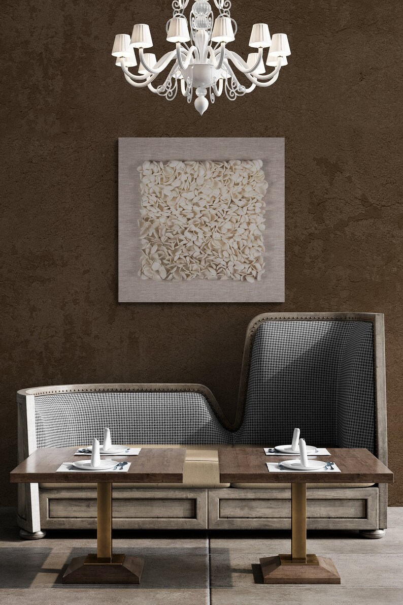 May include: A pair of wooden tables with brass legs and a checkered fabric booth in a restaurant setting. The tables are set with white plates and silverware. A white chandelier hangs from the ceiling above the booth.
