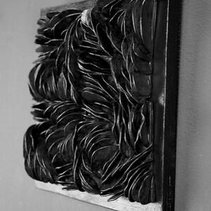 May include: Black and white abstract wall art made of layered, overlapping shapes. The artwork is framed in a black wood frame.