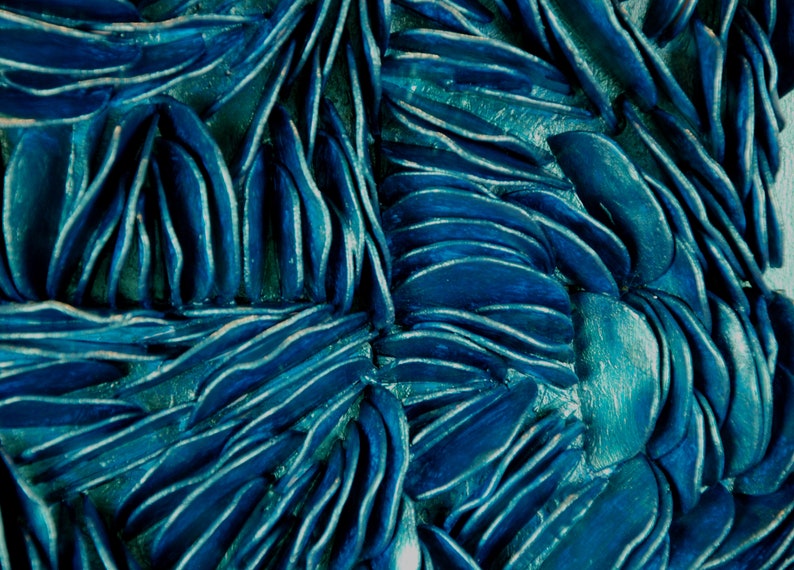 May include: A close-up of a textured blue surface made of overlapping, curved shapes. The surface has a metallic sheen and a slightly iridescent quality.