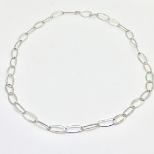May include: A silver chain necklace with oval links.