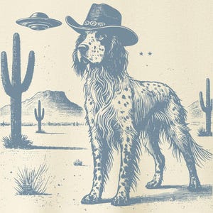 Może przedstawiać: Kremowa koszulka z niebieską grafiką przedstawiającą psa w kapeluszu kowbojskim na pustyni z kaktusami i UFO. Koszulka ma okrągły dekolt i krótkie rękawy. Logo marki "TACO DOG" znajduje się w prawym górnym rogu.