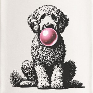 May include: A white t-shirt with a black and white illustration of a doodle dog blowing a pink bubble. The shirt has a white crew neck and the text "CANVAS" on the tag.