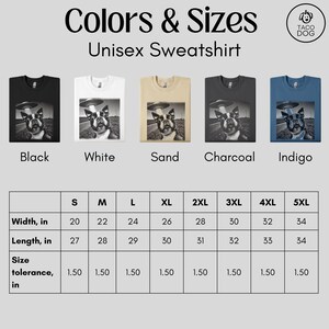 May include: Unisex sweatshirt available in black, white, sand, charcoal, and indigo. The sweatshirt features a graphic of a dog wearing a hat and standing in front of a flying saucer. Size chart with width and length measurements in inches.