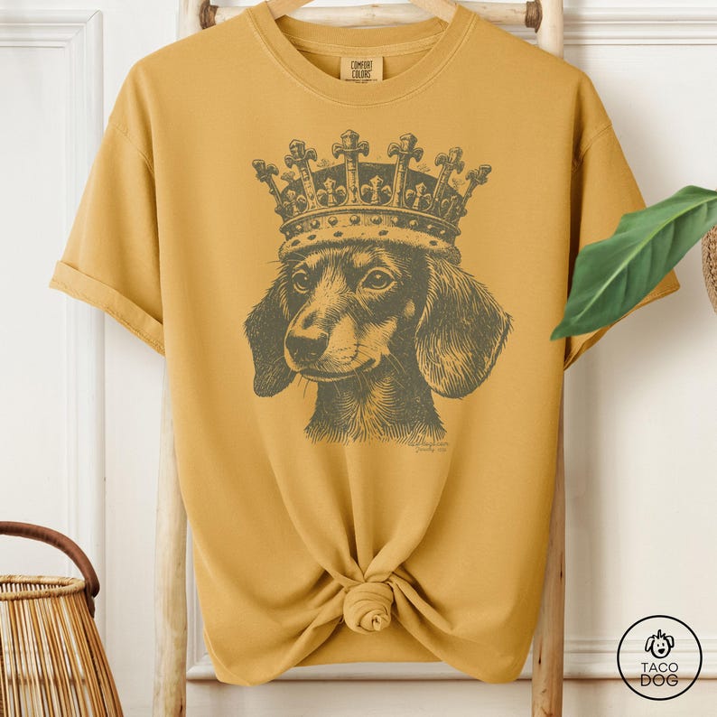 A t-shirt with a monochrome illustration of a dachshund wearing a crown.