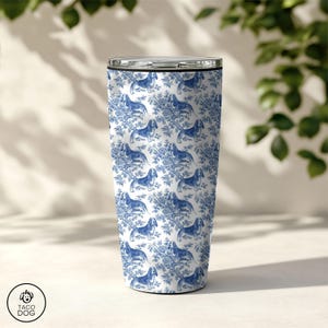 May include: A white and blue stainless steel tumbler with a pattern of blue basset hounds on a white background. The tumbler is 20 ounces.