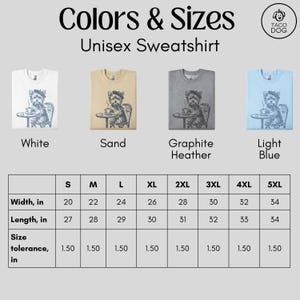 May include: Unisex sweatshirt in white, sand, graphite heather, and light blue. Each shirt features a graphic of a dog at a cafe table. Sizes range from S to 5XL, with width measurements from 20 to 34 inches.