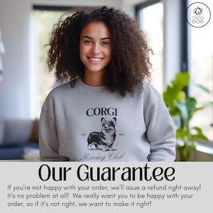 May include: A woman wearing a gray sweatshirt with a black and white illustration of a corgi dog. The sweatshirt has the text "CORGI Racing Club" and "EST. 1885".