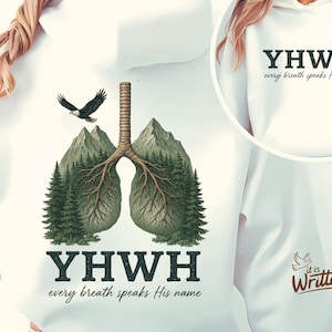Puede incluir: Sudadera blanca con un gráfico de un par de pulmones estilizados con raíces y árboles. El texto "YHWH every breath speaks His name" está impreso debajo del gráfico. El texto "YHWH every breath speaks His name" también está impreso en la parte delantera de la sudadera.