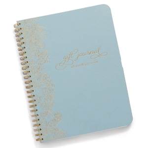 May include: A light blue spiral bound journal with a gold floral design and the text "gift journal gifts given & gifts received" on the cover.