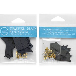 Pode incluir: Duas sacolas plásticas transparentes contendo pacotes de recarga de mapas de viagem. Cada pacote inclui bandeiras de papel preto e alfinetes dourados. O texto no rótulo diz "TRAVEL MAP Refill Pack" e "includes: 20 flags + 20 gold pins."