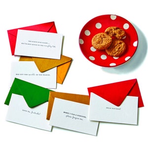 Könnte beinhalten: Ein Satz von acht Weihnachtskarten mit festlichen Botschaften. Die Karten sind in verschiedenen Farben, darunter Rot, Grün, Gold und Weiß. Die Karten enthalten Botschaften wie "You put the sparkle in the season." und "Love ya, fruitcake!"