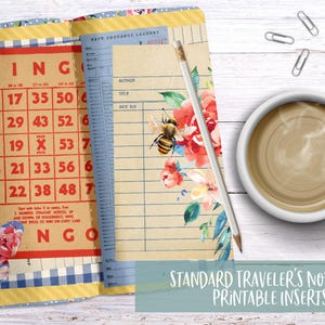 May include: Open notebook with bingo card and lined pages, floral and bee accents. A pencil rests on the pages next to a steaming cup of coffee. The text "STANDARD TRAVELER'S NOTEBOOK PRINTABLE INSERTS" is at the bottom.