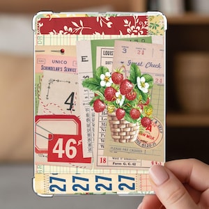 May include: A rectangular tablet case featuring a collage of vintage ephemera, including guest checks, ledger paper, and red labels with the number 46. A central illustration depicts a woven basket filled with red strawberries and white flowers.