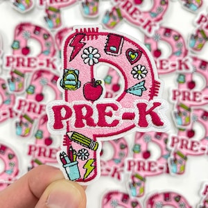 May include: Pink and white embroidered patch with the text "PRE-K". The patch is shaped like the letter "P" and features school-themed illustrations such as an apple, backpack, and pencil. The patch is surrounded by other similar patches.