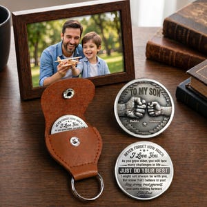 Peut inclure: Une photo encadrée d'un père et de son fils, un porte-clés en cuir marron avec une pièce de monnaie en argent et deux pièces de monnaie en argent avec des messages gravés. Une pièce dit "TO MY SON" et l'autre dit "JUST DO YOUR BEST".