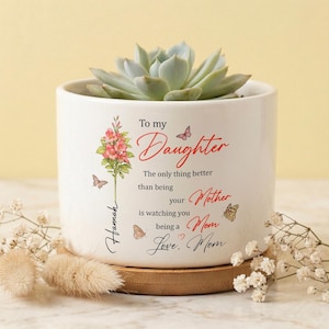 Puede incluir: Una taza de cerámica blanca con un asa negra y el texto "But First, Coffee" en negro y negrita. La taza está sobre una superficie de madera. La taza mide aproximadamente 10 cm de alto.