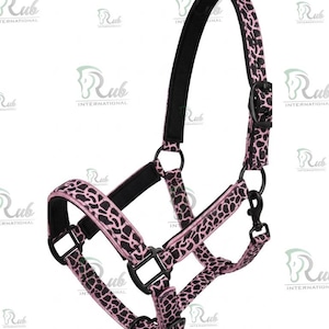 May include: A pink and black patterned horse halter. The halter features a black padded headstall and noseband for comfort. The hardware is black, including the adjustable buckles and the snap hook for easy attachment.