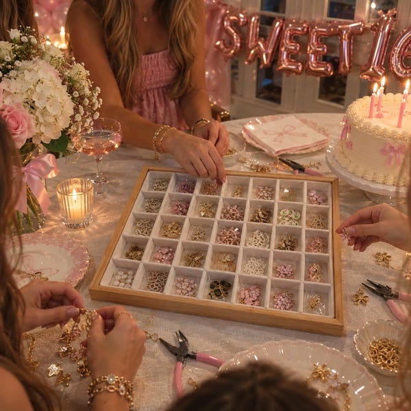Può includere: Un vassoio organizer quadrato in legno con trentasei scomparti individuali riempiti con piccoli ciondoli in metallo assortiti di varie forme, inclusi fiori e cuori, nelle tonalità oro, argento, bianco e rosa, per la creazione di gioielli.