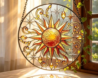 May include: A circular stained glass suncatcher featuring a central textured amber sun with radiating golden rays, surrounded by swirling vine patterns, small glass beads, and star shapes, all encased in a dark metal frame with a hanging chain.
