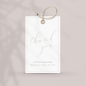 May include: A white gift tag with a delicate script that reads "thank you." The tag includes the words "with love and gratitude" and the names "MARTHA AND ALLEN." A beige string is attached to the top of the tag.