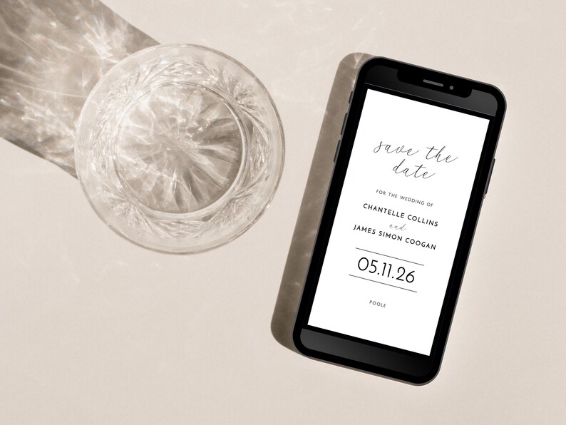 Contemporary paperless wedding save the date e-card shown on a smartphone next to a crystal tumbler