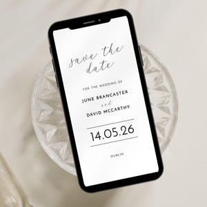 Smartphone save the date with contemporary black and white design shown on a smartphone poisoned on a small glass dish