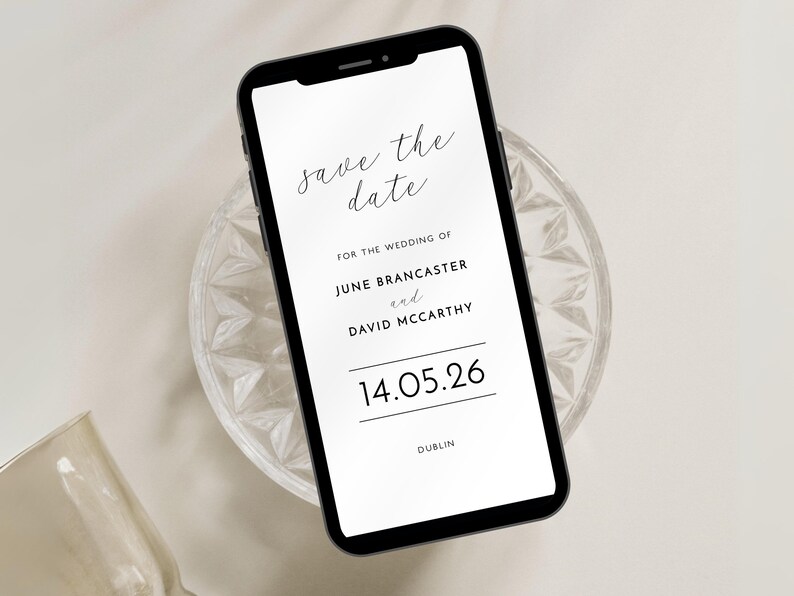 Smartphone save the date with contemporary black and white design shown on a smartphone poisoned on a small glass dish