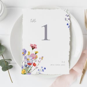 Romantic wildflower wedding table number displayed on a place setting