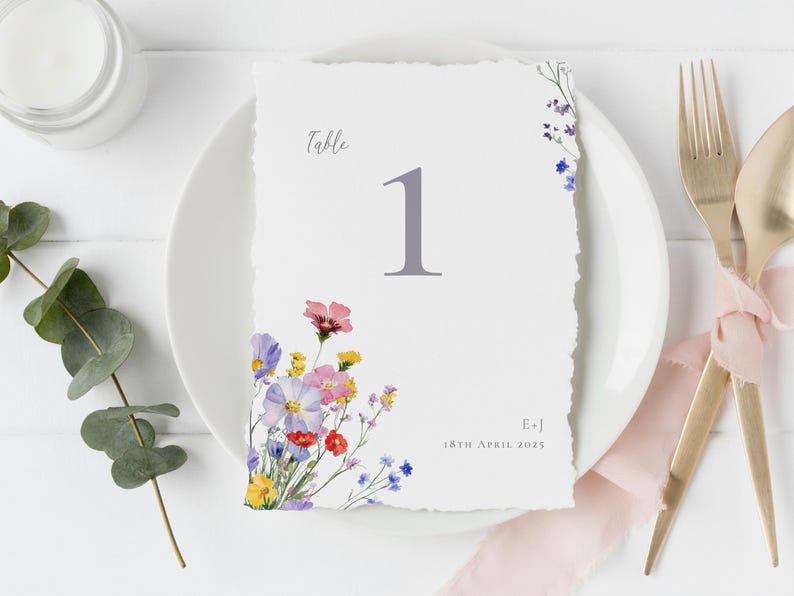 Romantic wildflower wedding table number displayed on a place setting