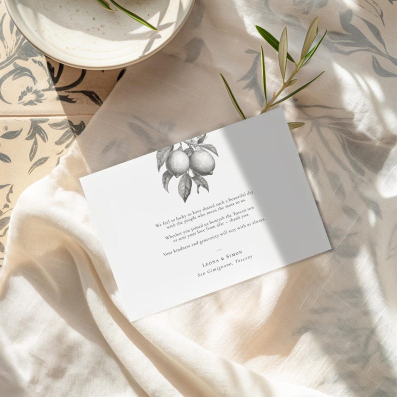 Lemon design wedding thank you card with pre-printed message, A6 size, laid on sheer fabric on Mediterranean tiles with an olive sprig
