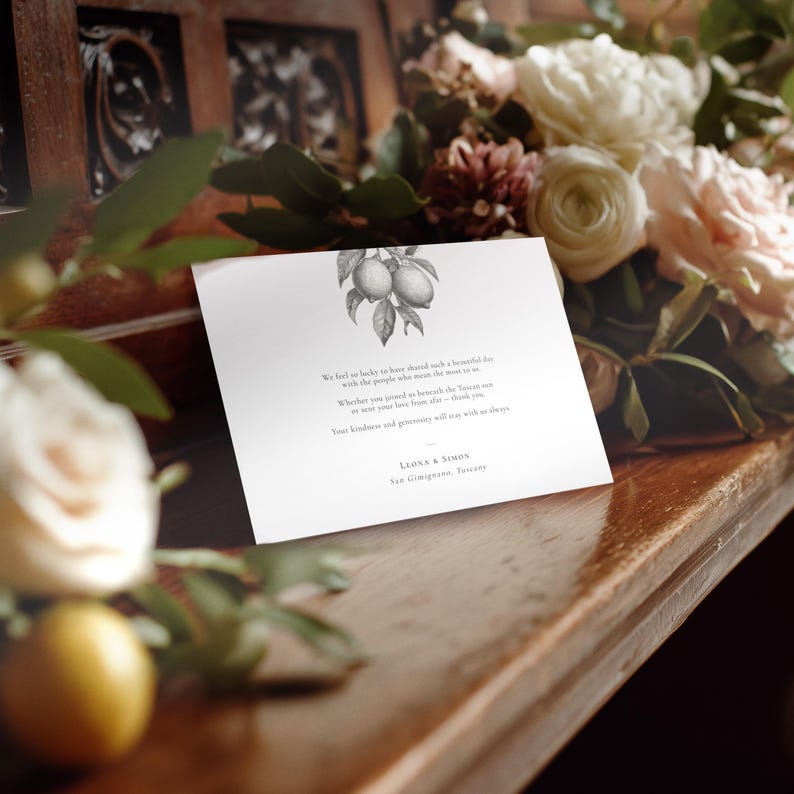 Elegant lemon wedding thank you card, pre-printed with a message, styled on a church pew with roses to the side and a lemon in the foreground.
