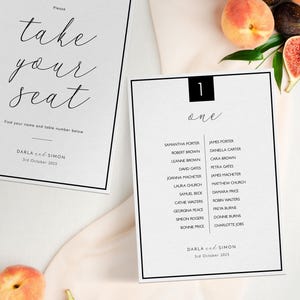 May include: Elegant wedding seating chart with black borders and calligraphy text. One chart reads "take your seat" and the other lists names under "one". Includes the date "3rd October 2025".