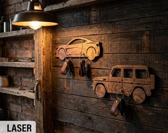 May include: Two wooden wall-mounted key holders shaped like vehicles. The top holder is a sports car silhouette with two metal hooks holding key fobs. The bottom holder is an SUV silhouette with one metal hook holding a key fob.