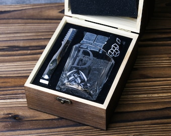 May include: A wooden box with a glass whiskey tumbler, ice cubes, and a metal ice tong. The tumbler has a letter D etched on the side.