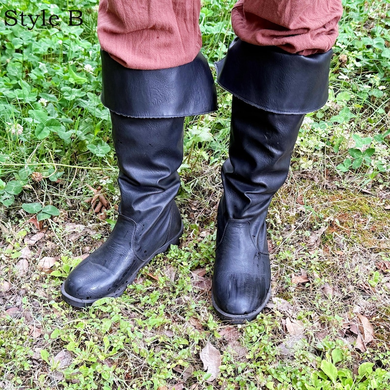 May include: Black knee-high boots with a folded-over cuff. The boots are made of a smooth, dark material and are worn with reddish-brown trousers. The boots are shown outdoors in a grassy area. The text "Style B" is in the upper left corner.