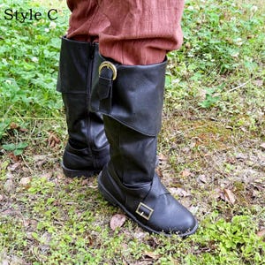 May include: Black leather boots with a fold-over cuff and buckle details. The boots have a side zip and are worn with reddish-brown trousers. The text "Style C" is in the upper left corner.
