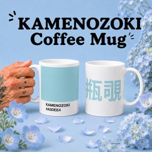 May include: Two white coffee mugs with the text "KAMENOZOKI Coffee Mug" in black. One mug has a light blue color block with the text "KAMENOZOKI #A5DEE4". The other mug has light blue Japanese characters.