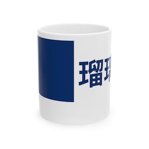 Peut inclure: Mug en céramique blanche avec un carré bleu et des caractères japonais imprimés. Le mug est cylindrique et possède une anse. Le texte est en gras, sans empattement.