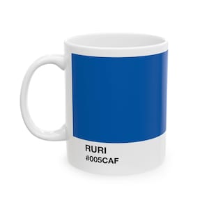 May include: White ceramic mug with a blue color block design. The mug features the name "RURI" and the color code "#005CAF" printed on the front. The mug has a curved handle for easy gripping.