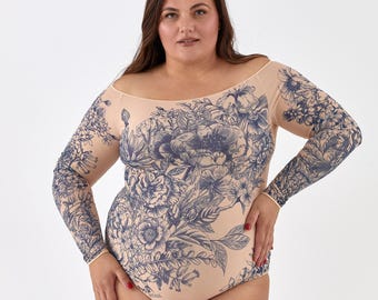 Op de afbeelding: Een huidkleurige bodysuit met lange mouwen en een off-the-shoulder halslijn. De bodysuit is versierd met een groot blauw bloemenpatroon. De mouwen eindigen met een dunne, lichtgekleurde rand. Het bloemendesign bedekt de hele voorkant en mouwen.