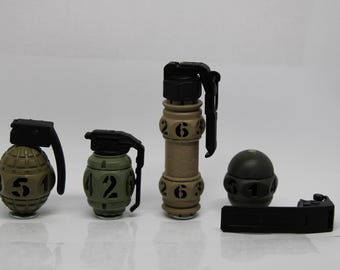 May include: An assortment of toy grenades in various sizes and designs. The grenades are primarily olive green and tan, with black handles and numerical markings. The collection includes a fragmentation grenade, a flashbang, and a smoke grenade.