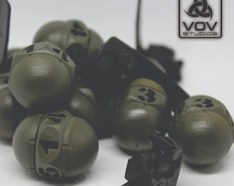 May include: A close-up of a group of small, green, round objects with numbers on them. The objects are arranged in a pile and some are partially obscured by black objects. The text "VOV STUDIOS" is visible in the upper right corner of the image.